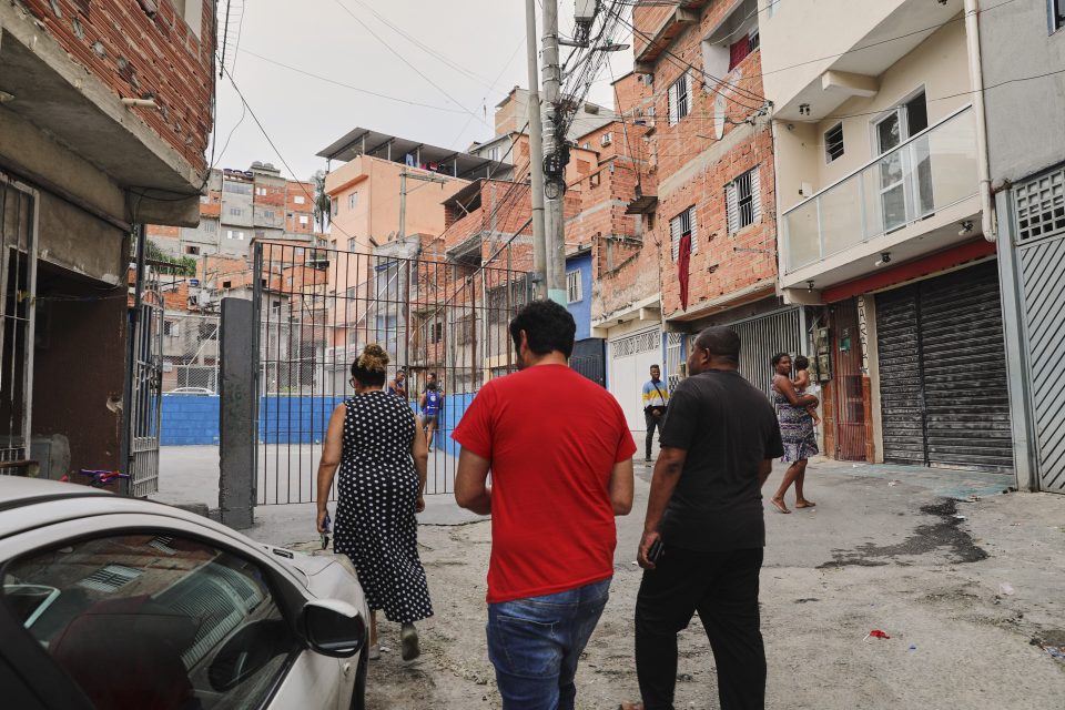 Ao lado do diretor do Sindipetro Unificado e trabalhador da Transpetro, Rodrigo Araújo, Adoracion e Pato caminham no Parque Savoy City, onde coordenam ações sociais e comunitárias ao lado do Comitê de Impacto Coletivo (Foto: Vítor Peruch/Sindipetro Unificado)